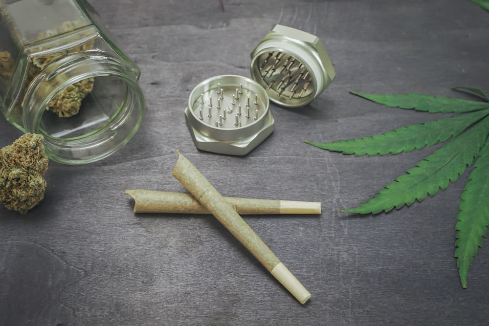 Picture of cannabis leaf, grinder, preroll joint jar of flower
